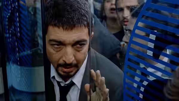 Marcos (Ricardo Darín) peers through a glass door as a crowd gathers behind him