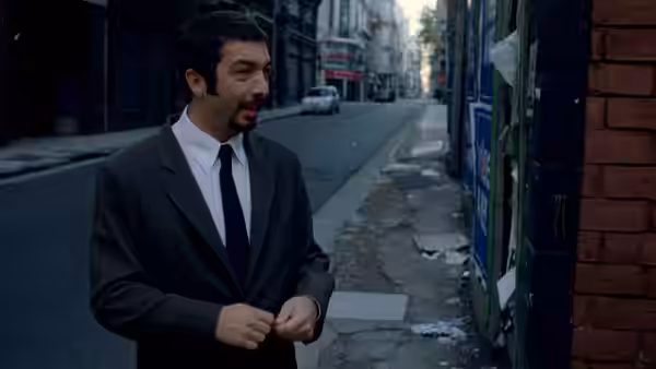 Marcos (Ricardo Darín) stands on a city sidewalk in a dark suit