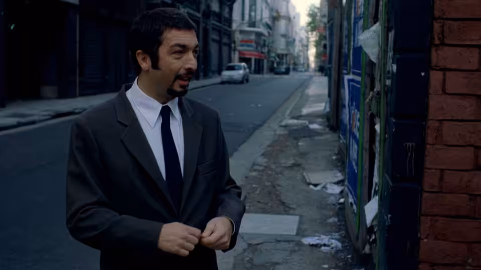 Marcos (Ricardo Darín) stands on a city sidewalk in a dark suit