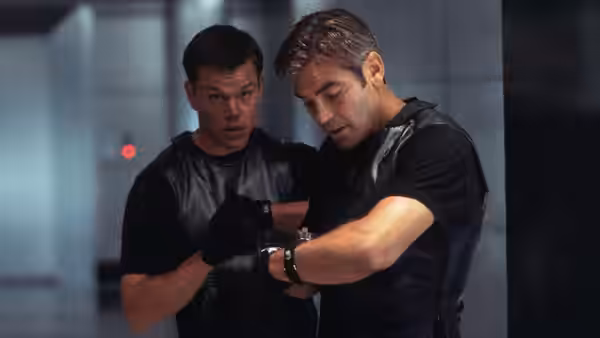 Linus Caldwell (Matt Damon) and Rusty Ryan (Brad Pitt) examining a wristwatch