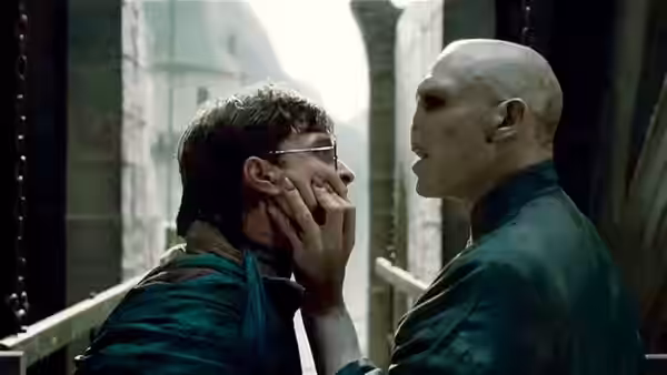 Lord Voldemort (Ralph Fiennes) grasping Harry Potter (Daniel Radcliffe) by the face