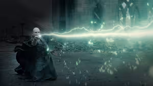 Lord Voldemort (Ralph Fiennes) kneeling and casting green lightning in a courtyard