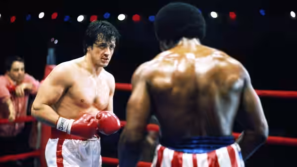 Rocky Balboa (Sylvester Stallone) faces Apollo Creed (Carl Weathers) in the ring
