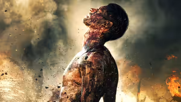 A blood-covered soldier standing amid smoke and flames on the battlefield