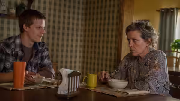 Robbie (Lucas Hedges) and Mildred (Frances McDormand) talk at a dining table