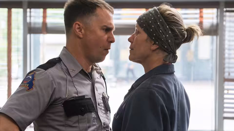 Dixon (Sam Rockwell) and Mildred (Frances McDormand) face each other closely indoors