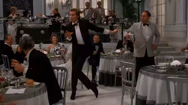 Nick Rivers (Val Kilmer) dances between tables in a crowded formal restaurant