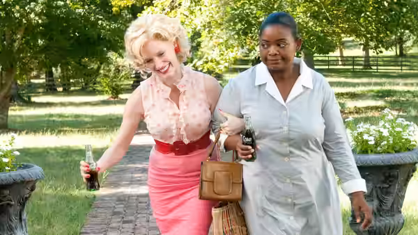 Celia Foote (Jessica Chastain) walks beside Aibileen Clark (Viola Davis)