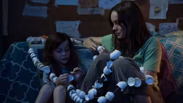 Ma (Brie Larson) and Jack (Jacob Tremblay) stringing egg shells on a bed