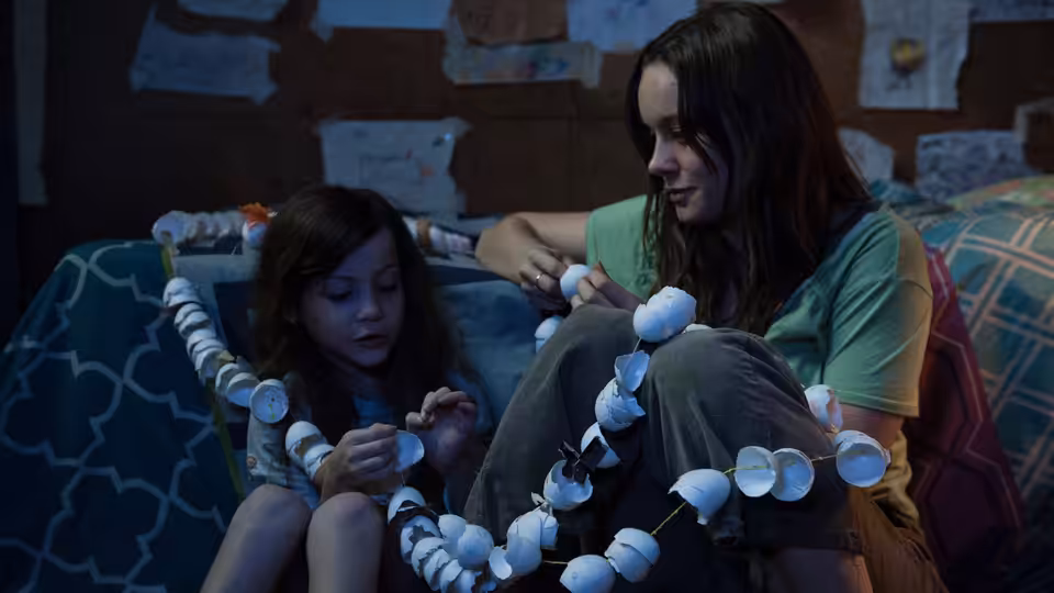 Ma (Brie Larson) and Jack (Jacob Tremblay) stringing egg shells on a bed