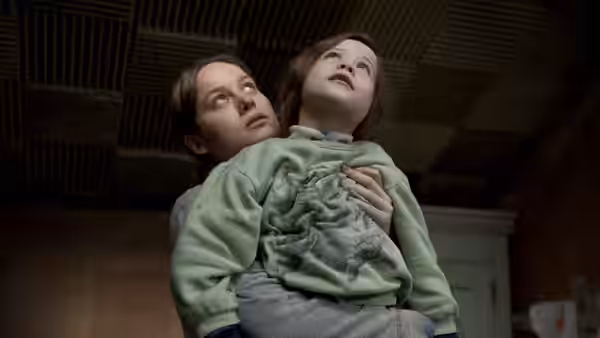 Ma (Brie Larson) holding Jack (Jacob Tremblay) while looking up at ceiling