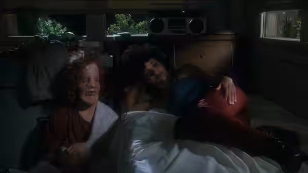 Rocky Dennis (Eric Stoltz) sits beside a reclining Rusty Dennis (Cher) in a bedroom