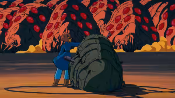 Nausicaä (Sumi Shimamoto) pushing a large shell before red creatures