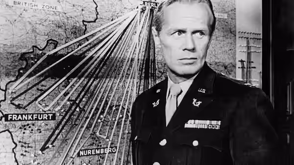 Officer studying a map of occupied Germany marked with Berlin and Nuremberg