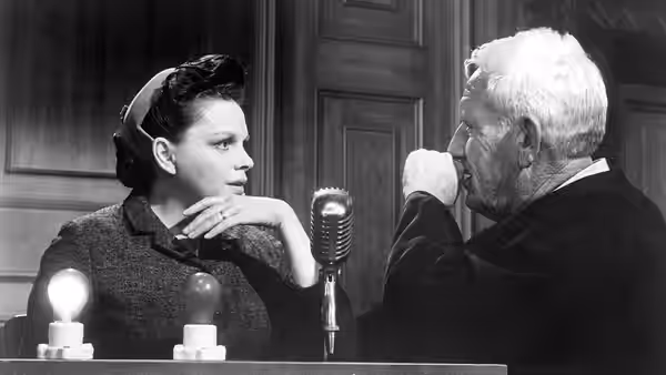 Mrs. Bertholt (Marlene Dietrich) speaking with Dan Haywood (Spencer Tracy)