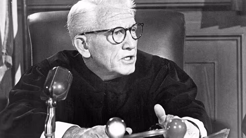 Dan Haywood (Spencer Tracy) speaking from the bench into a microphone