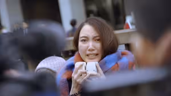 Shiori Itō holds a small recorder amid a crowd of cameras
