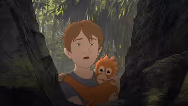 Michael holds a small orangutan close while peering anxiously through the jungle trees