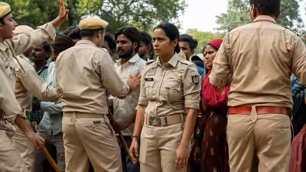 Constable Santosh Saini (Shahana Goswami) stands among police and villagers during a tense gathering