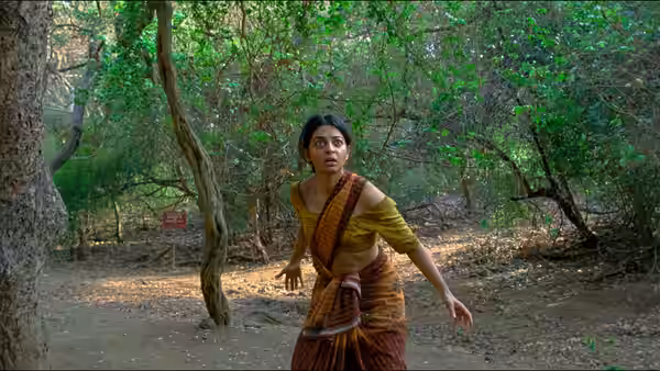 Uma (Radhika Apte) stands alert in a wooded clearing