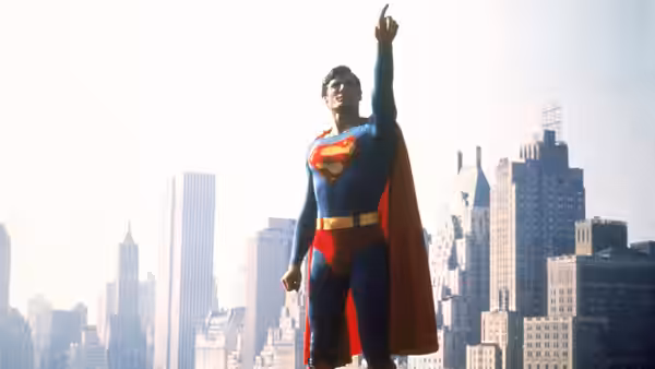 Christopher Reeve as Superman raises a hand above the New York City skyline