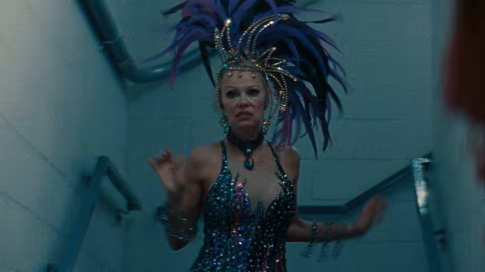 Shelly (Pamela Anderson) in a sequined showgirl costume moves through a backstage corridor