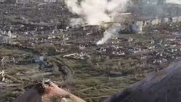 Smoke rises over a heavily damaged town viewed from above