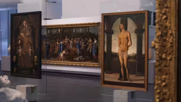 Large religious paintings hang on display in a museum gallery