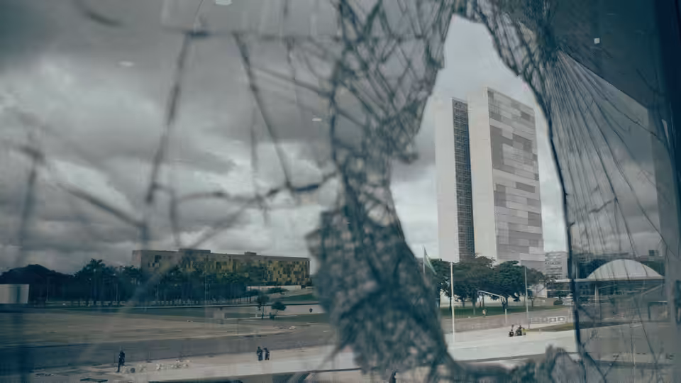 The National Congress buildings stand beyond cracked glass and a broad reflecting pool