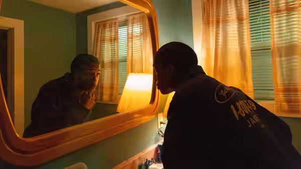 James (A$AP Rocky) leans over a bathroom sink, studying his reflection in the mirror