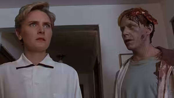 Rachel Creed (Denise Crosby) stands beside the bloodied, injured Victor Pascow (Brad Greenquist) indoors