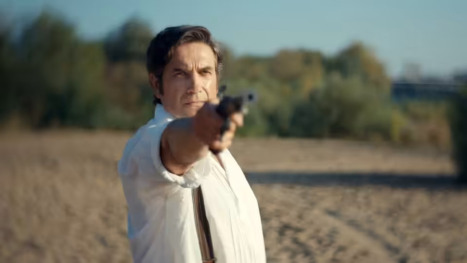 Stanisław Wokulski (Marcin Dorociński) aims a pistol across an open field