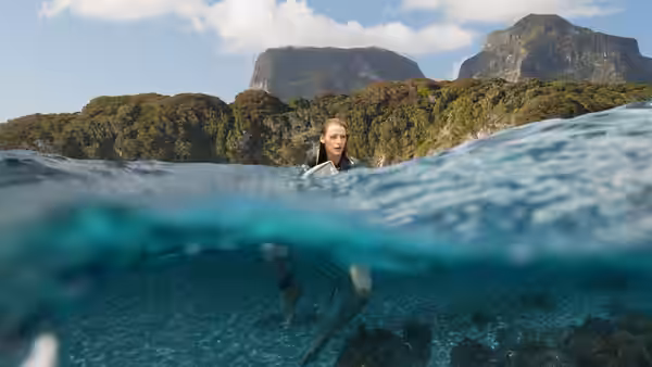 Nancy Adams (Blake Lively) swims near the surface beside a tropical island
