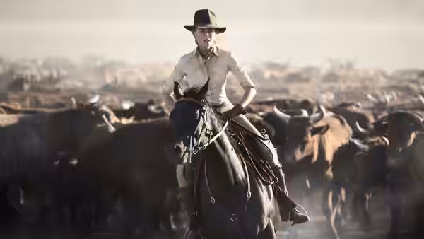 Lady Sarah Ashley rides horseback through a vast herd of cattle