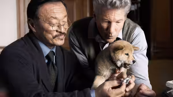 Ken (Cary-Hiroyuki Tagawa) and Parker Wilson (Richard Gere) examine a puppy