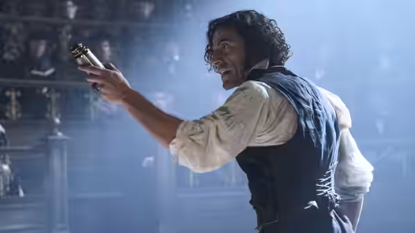 Victor Frankenstein (Oscar Isaac) raising a syringe in a grand hall