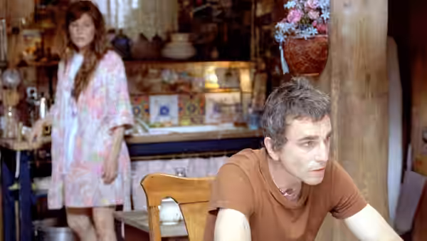 Jack Slavin (Daniel Day-Lewis) sits at a kitchen table as a woman stands behind him