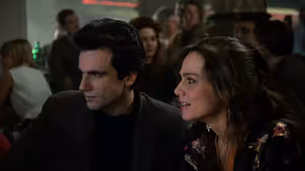 Tomas (Daniel Day-Lewis) and Sabina (Lena Olin) sit together in a crowded bar
