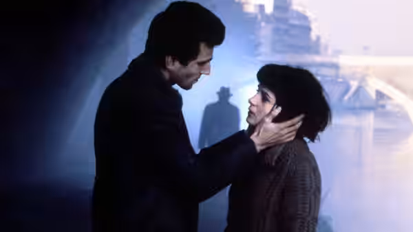 Tomas (Daniel Day-Lewis) cups Tereza’s (Juliette Binoche) face in a dim room