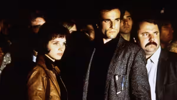 Tereza (Juliette Binoche) and Tomas (Daniel Day-Lewis) stand among a crowded gathering