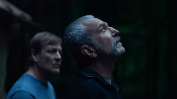 Ray Stoker (Daniel Day-Lewis) looks upward in the woods as Jem watches behind him