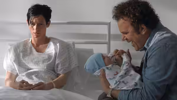 Eva (Tilda Swinton) in hospital gown beside Franklin (John C. Reilly) with infant