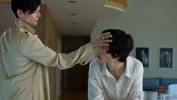 Eva (Tilda Swinton) touching Kevin's (Ezra Miller) forehead in a hallway