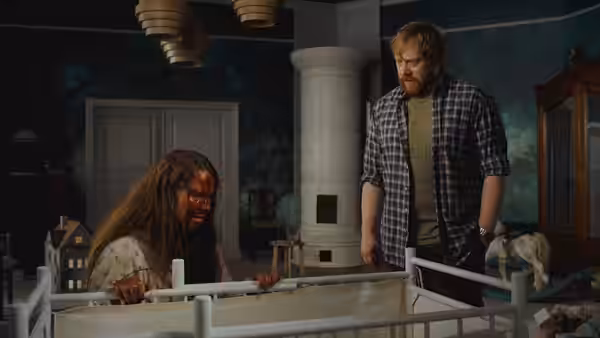 Jon (Rupert Grint) watches a long-haired woman crouched beside a baby’s crib