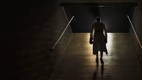 A boxer climbs a dimly lit ramp toward the arena entrance