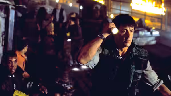 Kit Latura (Sylvester Stallone) signals to survivors gathered among wrecked cars in the tunnel