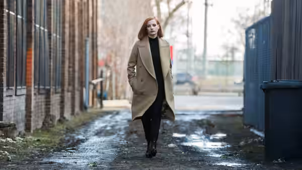 Madeline Sloane (Jessica Chastain) walks through a wet city alley in a long coat