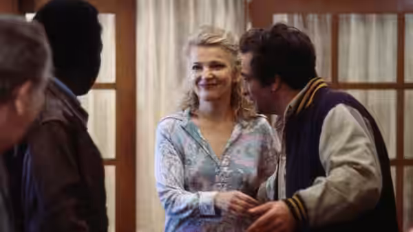Mabel Longhetti (Gena Rowlands) smiles beside Nick Longhetti (Peter Falk) among guests indoors