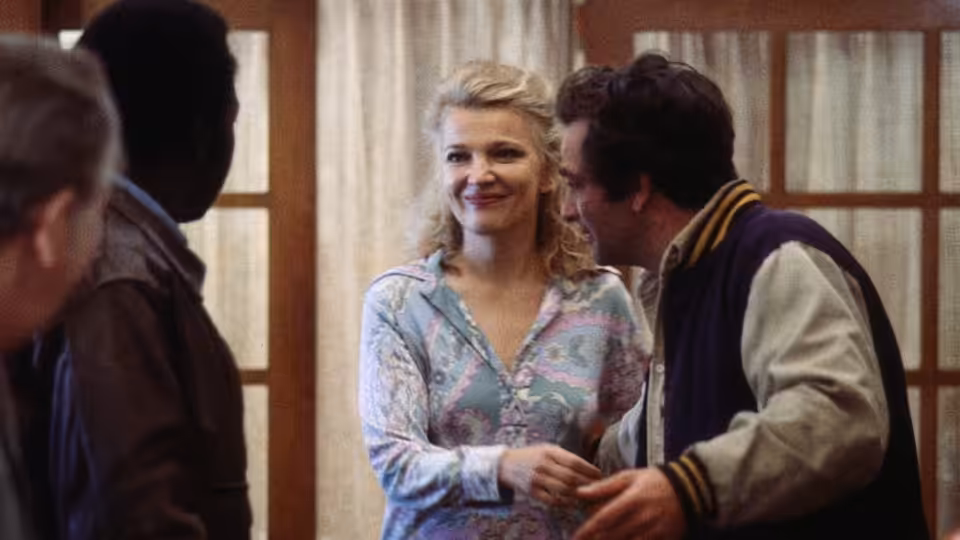Mabel Longhetti (Gena Rowlands) smiles beside Nick Longhetti (Peter Falk) among guests indoors