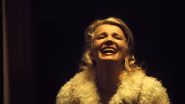 Mabel Longhetti (Gena Rowlands) throws her head back laughing in a fur coat